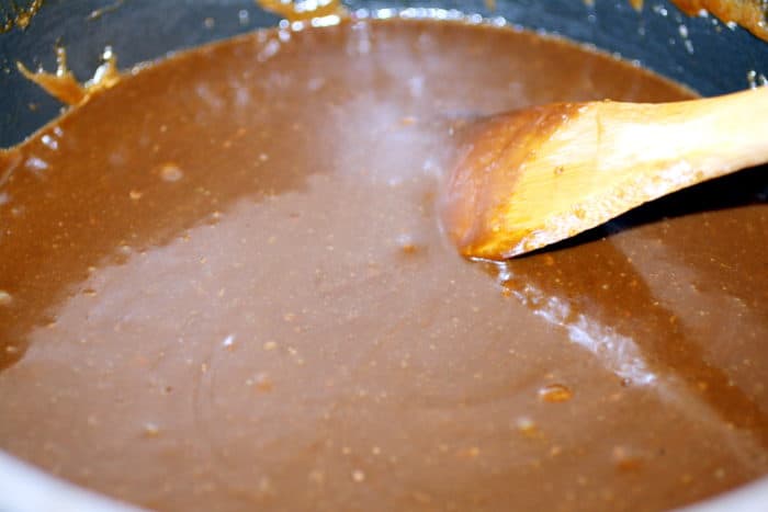 black pot with fudge mixture and a wooden spoon