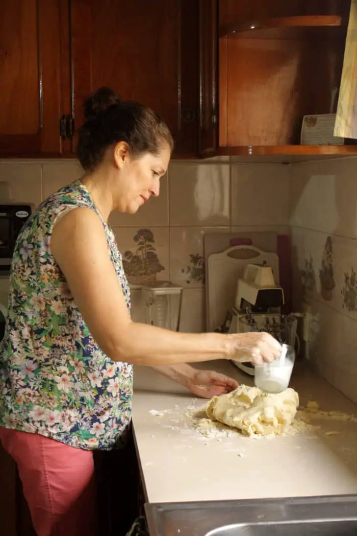 una mujer parada mezclando masa de chipa