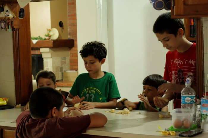 5 niños de diferentes edades haciendo chipa