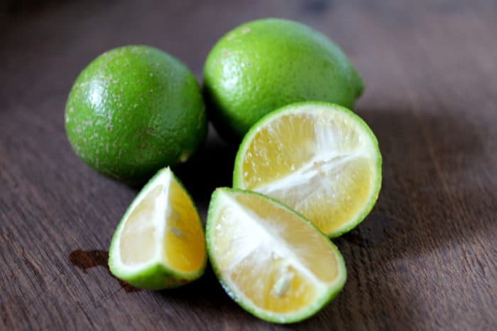 limones verdes sobre una madera