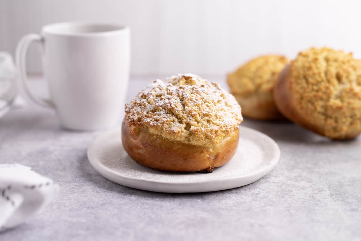 Portuguese Coconut Buns (Pão De Deus) with icing sugar sprinkled on top.