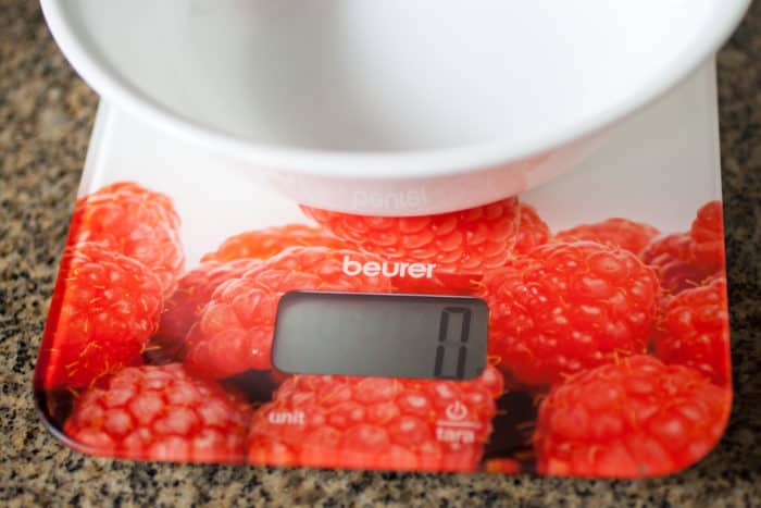 Kitchen scale with a white bowl on top. turn on.