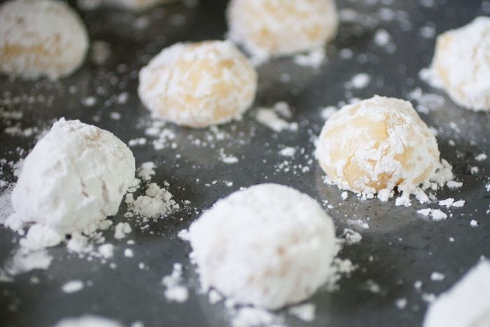 Ghreyba (Coconut Moroccan Cookies) dough covered in icing sugar on a baking tray.