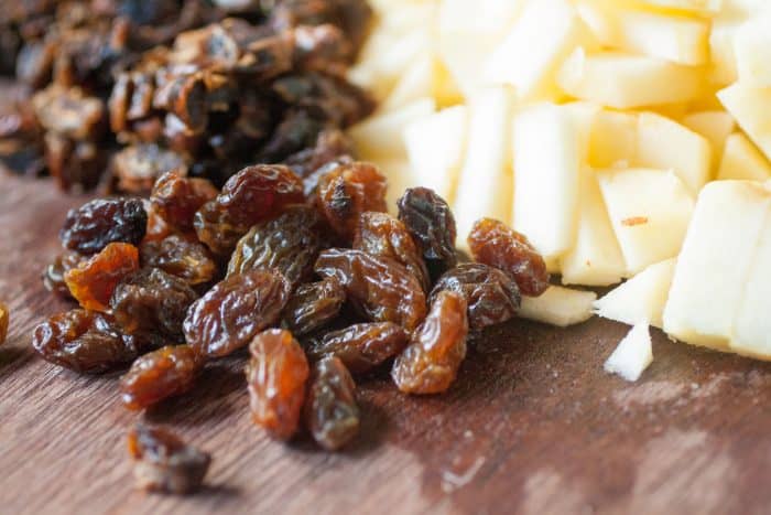 chopped apples, raisins and dates on a wood tray 