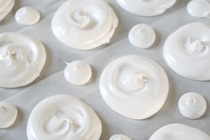 individual meringues on baking sheet