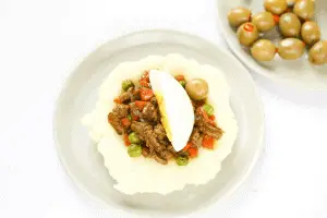 plate with olives, plate with mashed potatoes with meat in the middle
