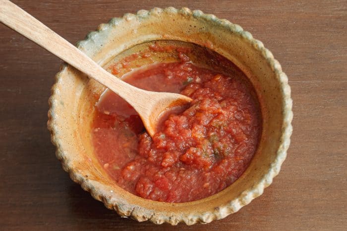 Bolivian spicy sauce, llajua in a bowl with a spoon
