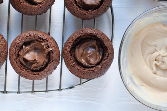 brownie cups on a cooling rack filled with chocolate