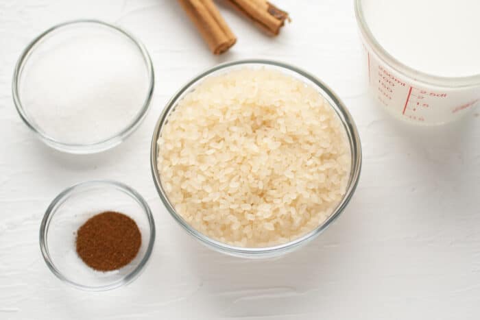 ingredients for bolivian rice pudding: rice, cinnamon, cloves, sugar and milk