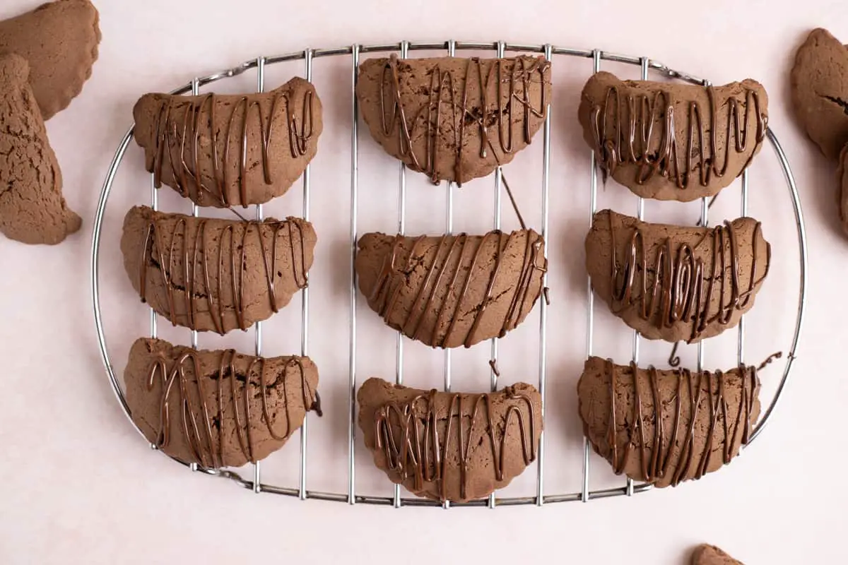 dulce de leche cookies drizzeled with chocolate on a cooling rack