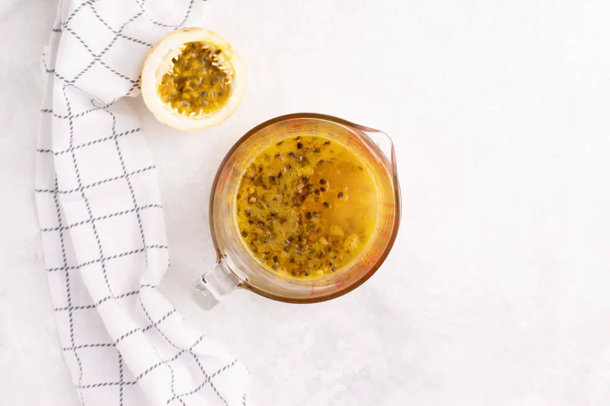 vaso con jugo de naranja y pulpa de maracuyá
