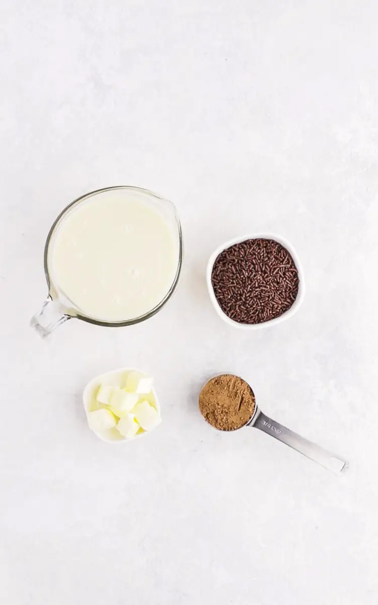 ingredients for Brazilian truffles, condense milk, chocolate sprinkles, butter, and cocoa powder